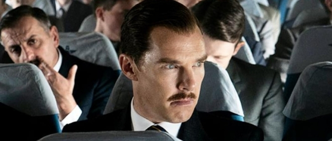 A close up of actor Benedict Cumberbatch sitting on a plane in a still from the film The Courier. 