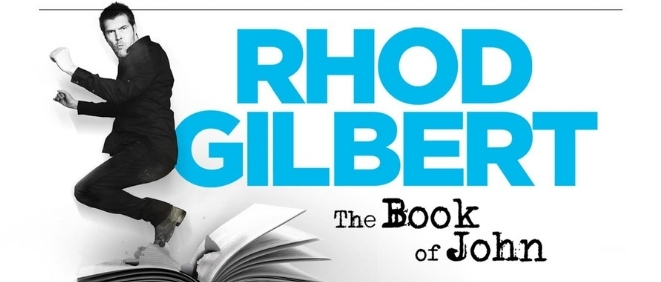 Comedian Rhod Gilbert jumps against a white backdrop with blue text reading 'Rhod Gilbert - The Book of John'
