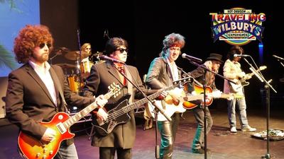 The cast of Roy Orbion and the Traveling Wilburys perform on stage. 