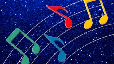 Brightly coloured musical notes against a sparkly blue background. 