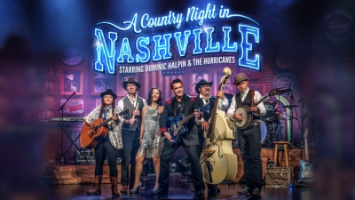The band members of A Country Night in Nashville stand on stage. 