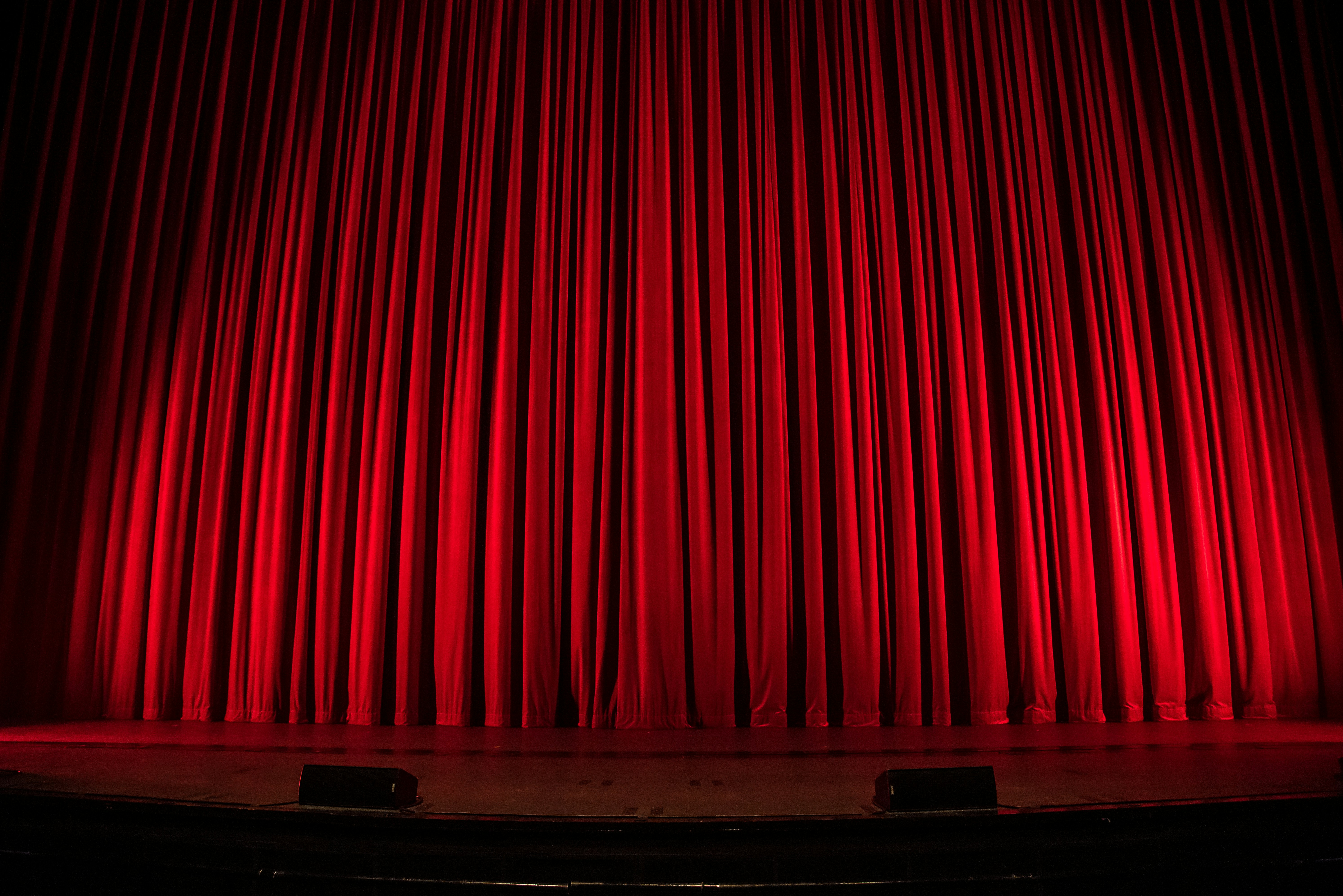 On the stage. Red theatre curtains with a spotlight on them.