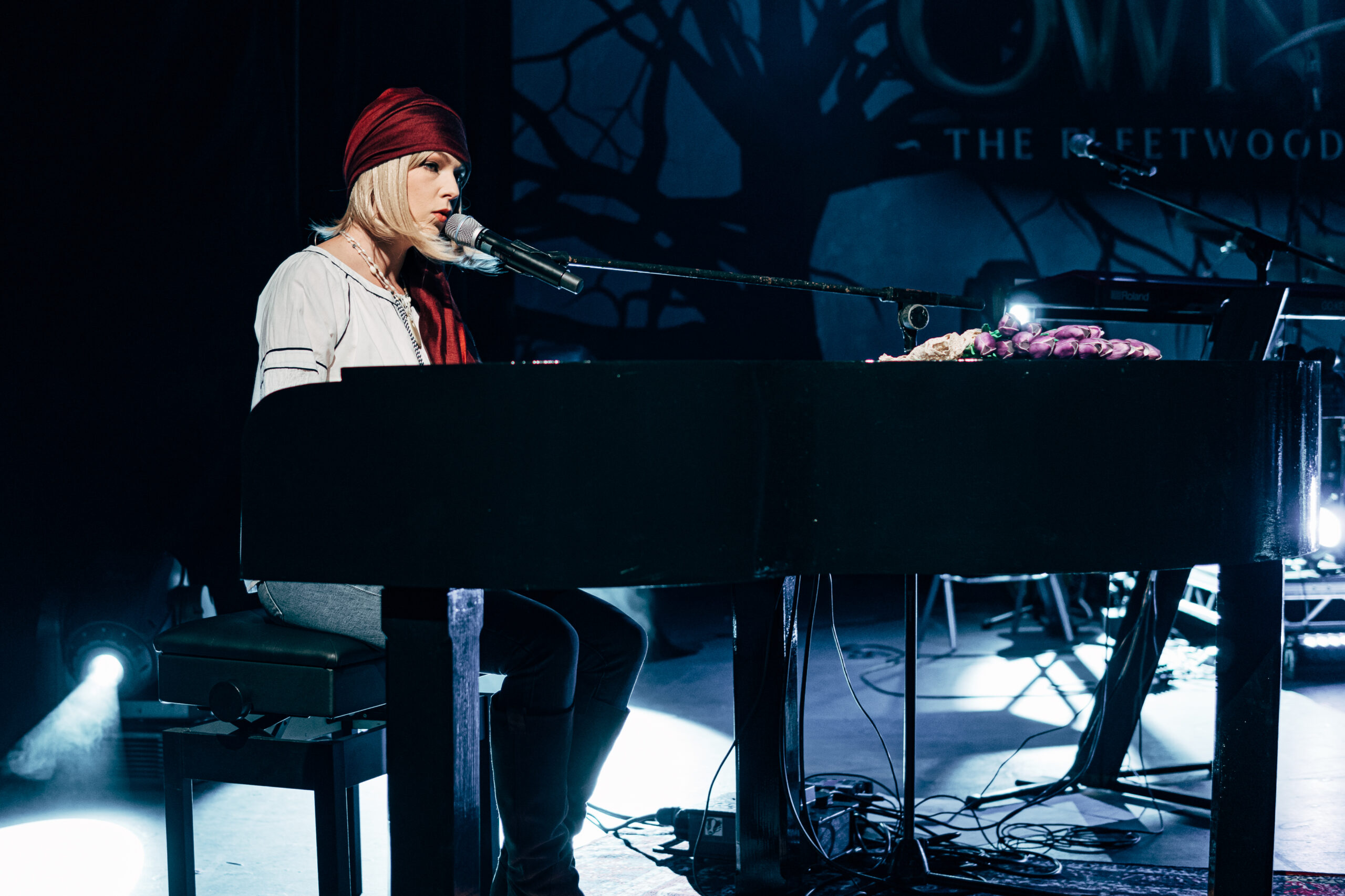 A member of The Fleetwood Mac Legacy plays the piano on stage. 