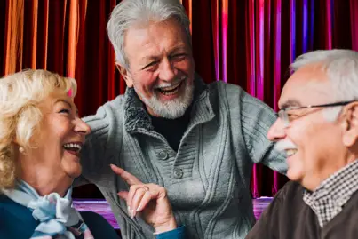 A group of three volunteers laugh at a shared joke.