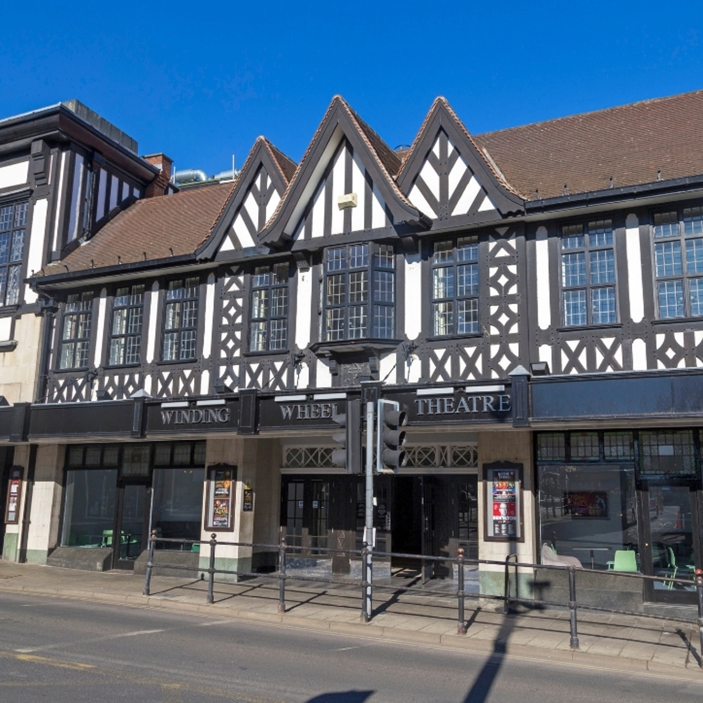 The Winding Wheel Theatre. A mock Tudor building. The sky above is clear and blue.