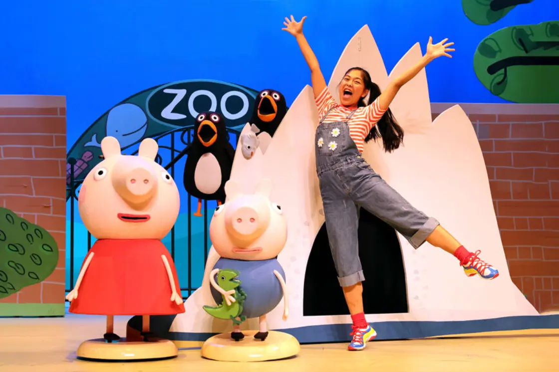 Peppa Pig and George stand in front of the entrance to a zoo.